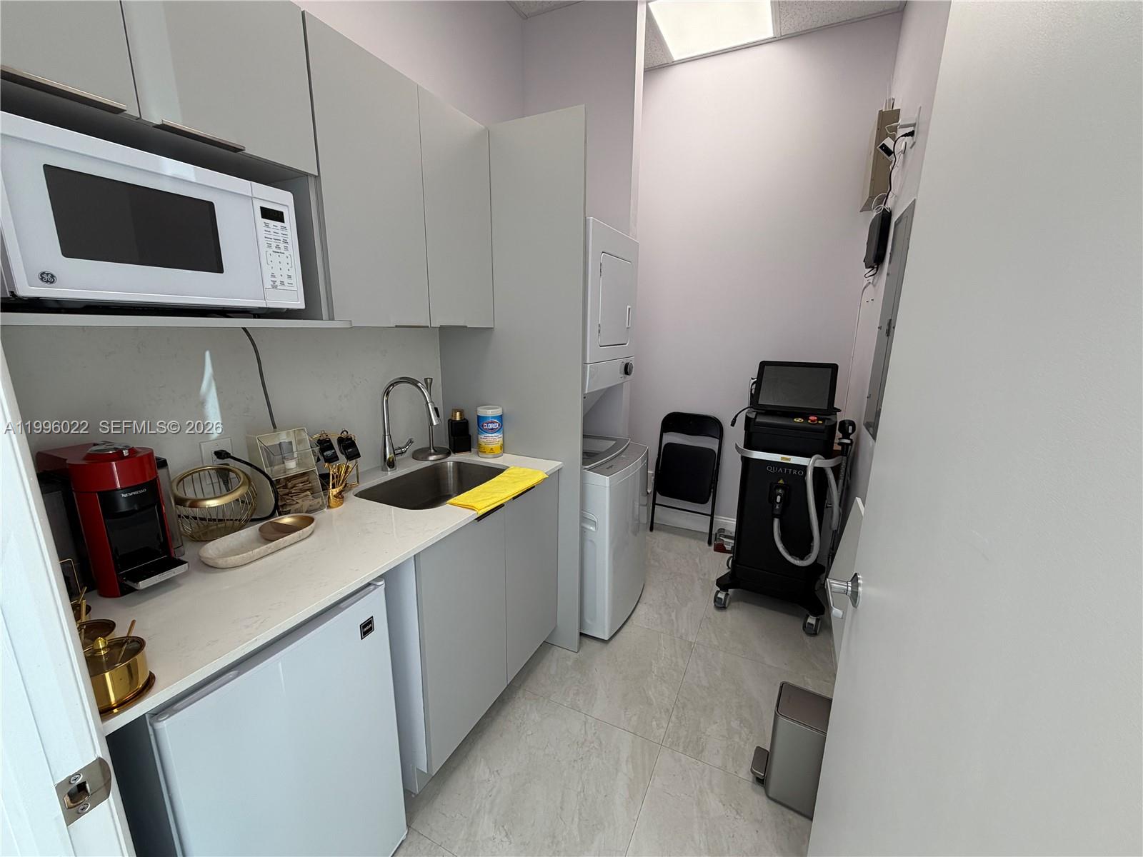 A small utility room features a kitchenette, laundry appliances, and a medical laser device — MED SPA FOR SALE, Miramar FL 33025, MIRAMAR, FL
