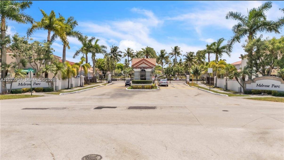 The gated entrance to Melrose Parc features a guardhouse, palm trees, and paved roads — 16628 SW 47th Ter, Miami FL 33185, MIAMI, FL