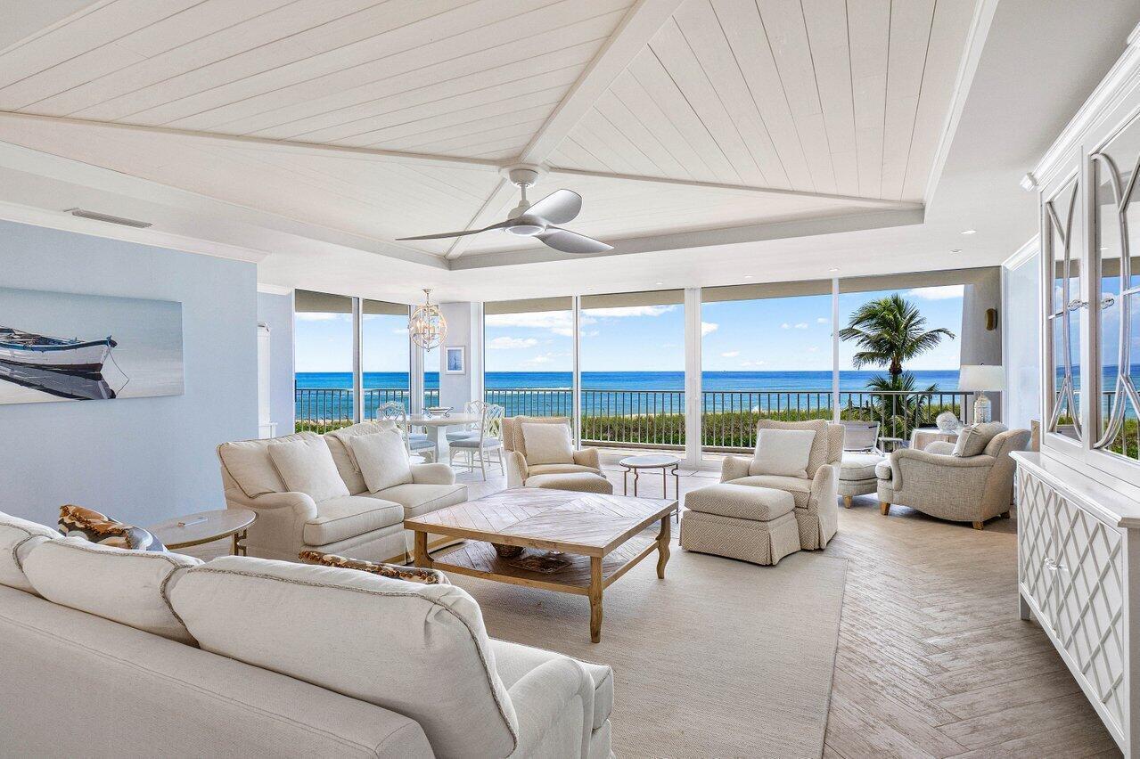 A bright living room features white furniture, a wooden coffee table, and ocean views — 2001 SE Sailfish Point Boulevard # 212, Stuart FL 34996, STUART, FL