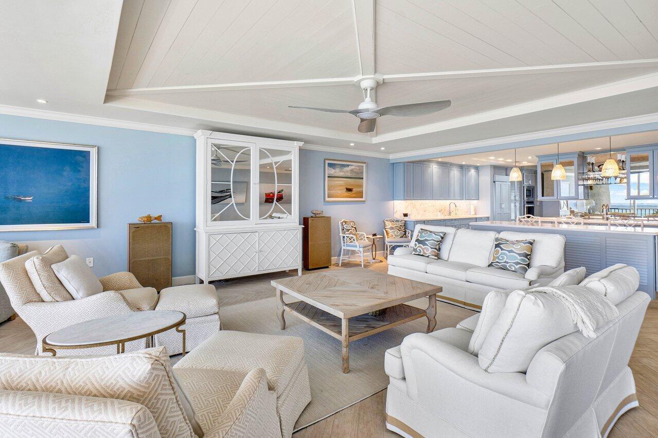 A bright living room features light blue walls, white furniture, and a coffered ceiling — 2001 SE Sailfish Point Boulevard # 212, Stuart FL 34996, STUART, FL