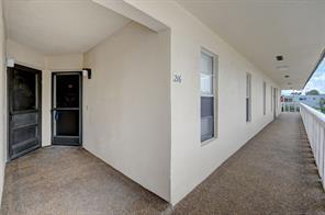 An exterior walkway leads to the entrance of a residential unit with a screen door — 342 Southwind Drive # 216, North Palm Beach FL 33408, NORTH PALM BEACH, FL