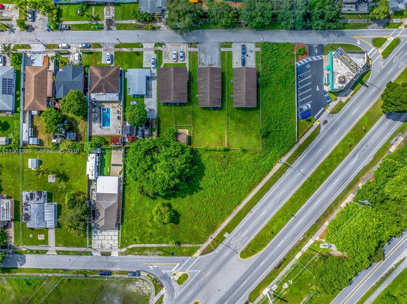 Aerial view of a residential neighborhood with houses, a large vacant lot, and adjacent roads — 214 S Dixie Hwy, Miami FL 33189, MIAMI, FL