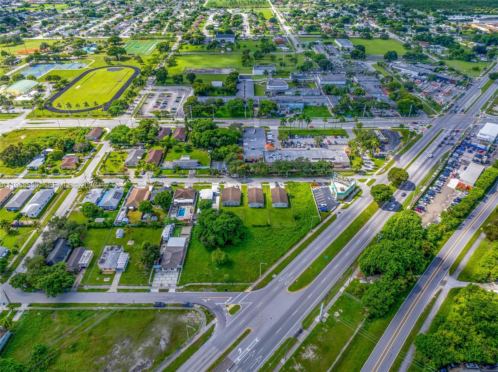 An aerial view shows a suburban neighborhood with houses, a school, and a multi-lane road — 214 S Dixie Hwy, Miami FL 33189, MIAMI, FL