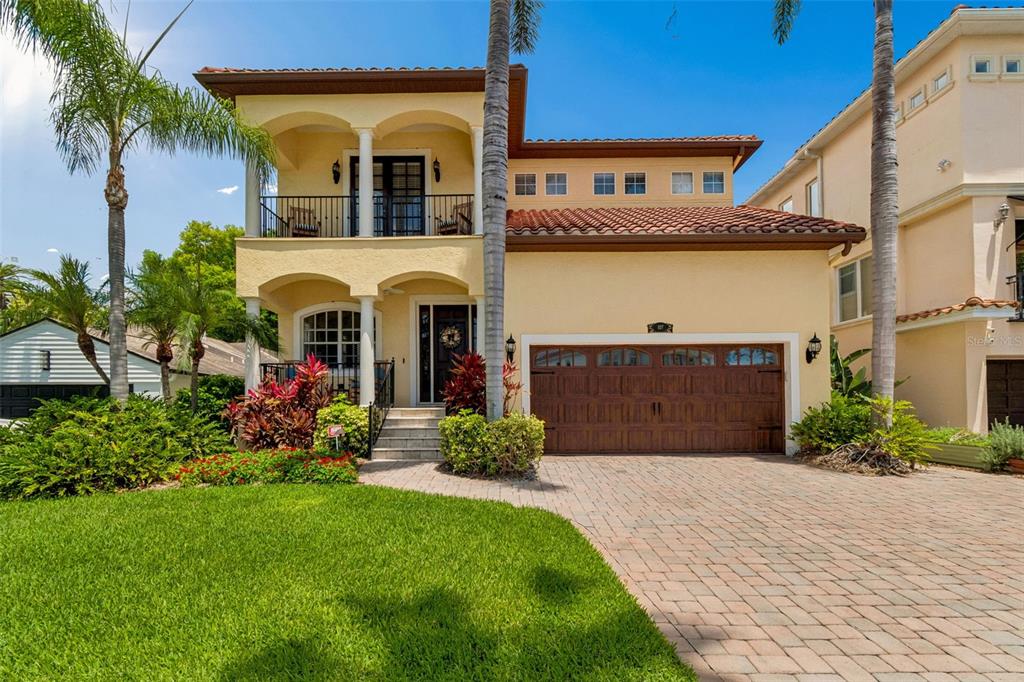 A two-story stucco house with a tiled roof, a balcony, and a paved driveway — 107 BERMUDA AVENUE, TAMPA, FL