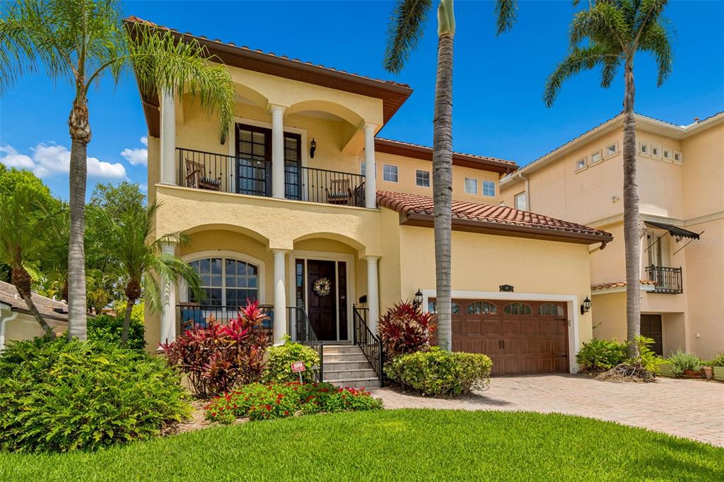A two-story yellow stucco house with a tiled roof, balcony, and attached garage — 107 BERMUDA AVENUE, TAMPA, FL