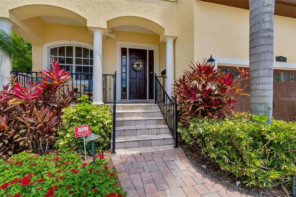 The exterior of a house features a paved walkway leading to a front porch with stairs — 107 BERMUDA AVENUE, TAMPA, FL