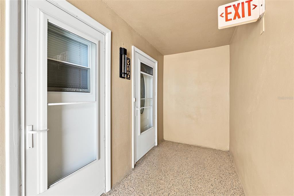 An exterior entryway features two white doors, a black address sign, and an exit sign — 1 BOCA CIEGA POINT BOULEVARD UNIT 316, ST PETERSBURG, FL