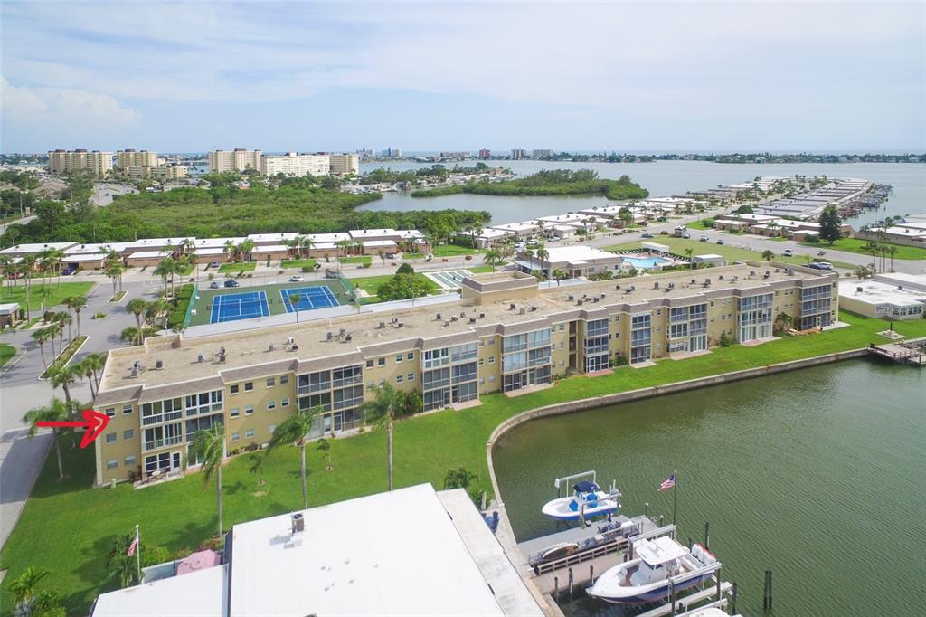 An aerial view of a multi-story apartment building next to a canal and boat docks — 1 BOCA CIEGA POINT BOULEVARD UNIT 316, ST PETERSBURG, FL