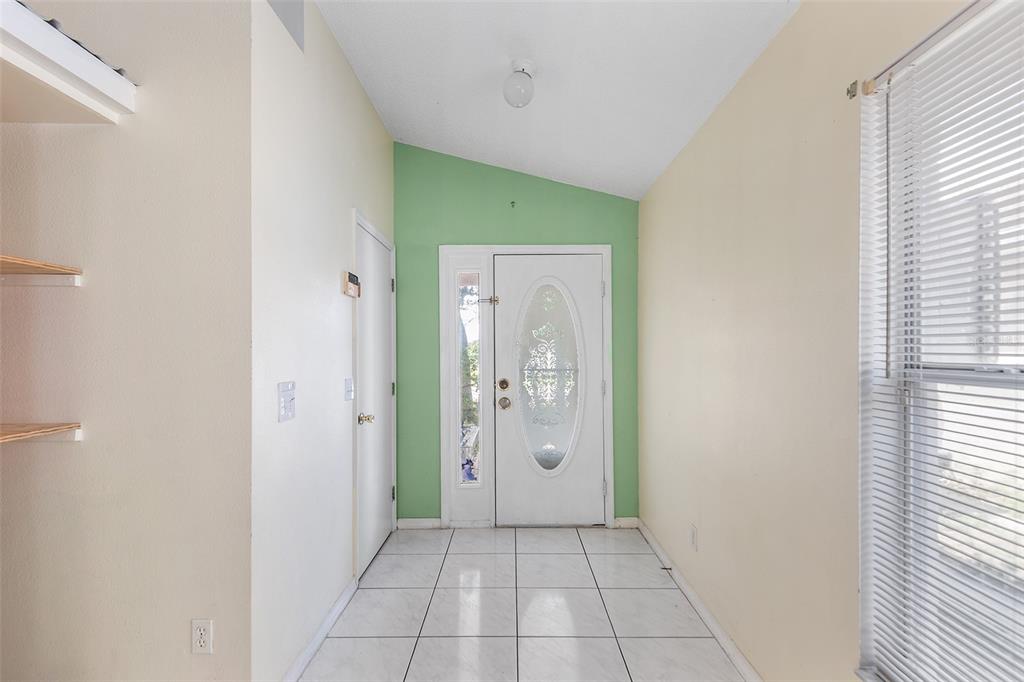 A tiled room features a white ceiling fan, light-colored walls, and built-in shelving — 9616 HOLLYHILL DRIVE, ORLANDO, FL