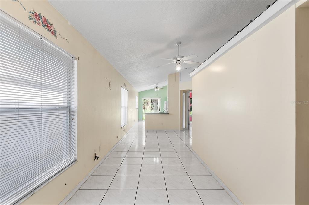 A room with white tiled floors, light yellow walls, a ceiling fan, and two windows — 9616 HOLLYHILL DRIVE, ORLANDO, FL