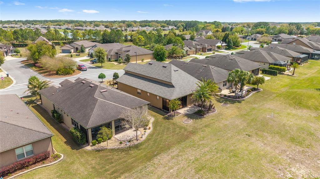 An aerial view shows several suburban houses with dark roofs and screened-in lanais near a road — 6816 SW 95TH CIRCLE, OCALA, FL