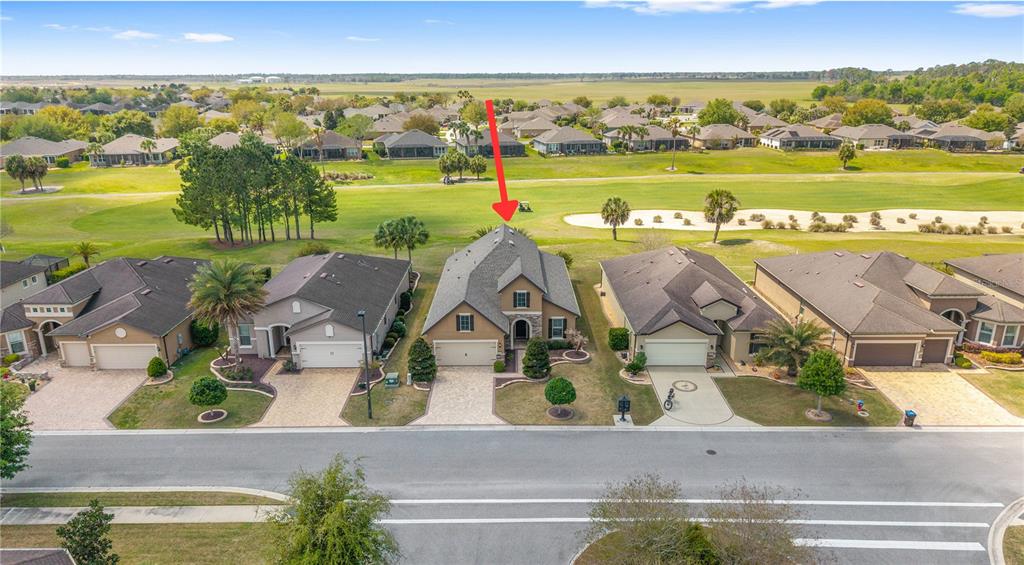 An aerial view of a suburban house with a red arrow pointing to its roof — 6816 SW 95TH CIRCLE, OCALA, FL