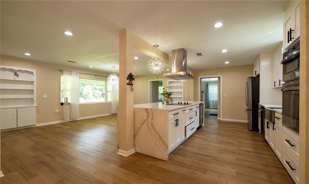 A kitchen with a marble-topped island, stainless steel appliances, and light wood-look flooring — 298 N COURT STREET, BRONSON, FL