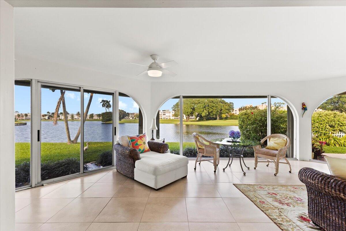 A sunroom with tile floors and large sliding glass doors overlooking a lake and golf course — 233 Rio Vista Circle # 233, Atlantis FL 33462, ATLANTIS, FL