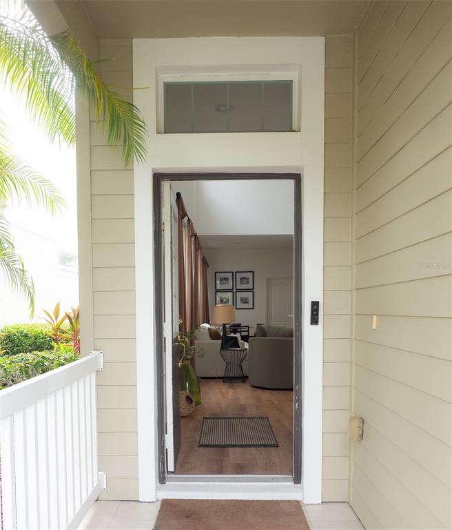 A view through an open front door into a living room with wood-look flooring — 20065 HERITAGE POINT DRIVE, TAMPA, FL