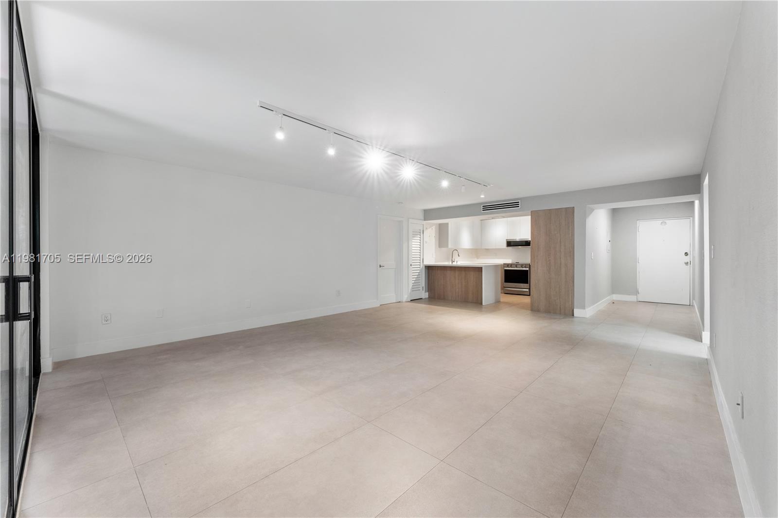 An open-concept living area features light-colored tile flooring, white walls, and a modern kitchen — 55 Ocean Lane Dr # 1031, Key Biscayne FL 33149, KEY BISCAYNE, FL