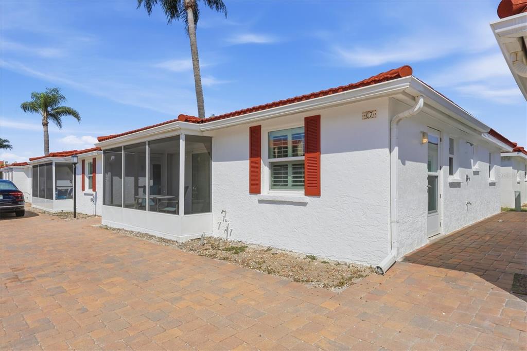 A white stucco villa with red roof tiles, red shutters, and a screened-in porch — 6154 MIDNIGHT PASS ROAD UNIT 7C, SARASOTA, FL