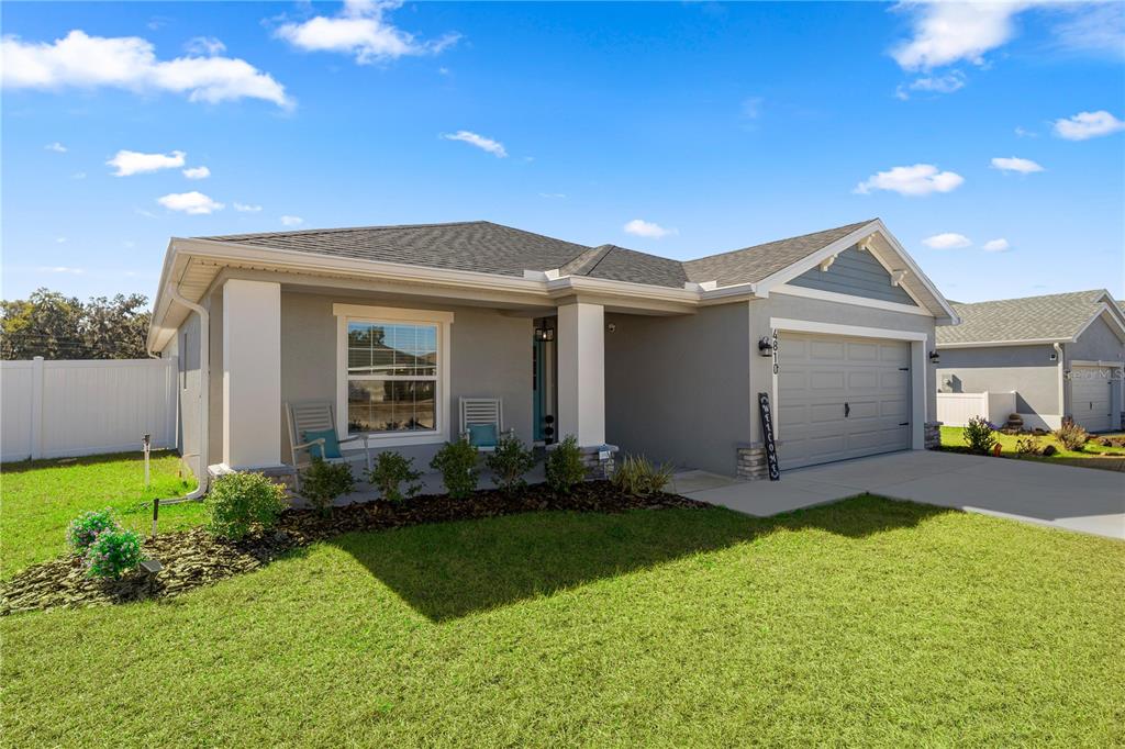 A single-story house with a gray exterior, a two-car garage, and a front porch — 4810 SE 91ST PLACE, OCALA, FL