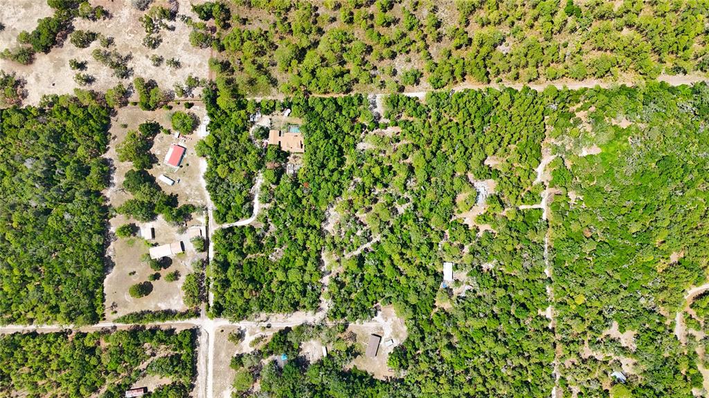 An aerial view shows a rural property with several houses, outbuildings, and dense wooded areas — 0 WINDHAVEN LANE, BROOKSVILLE, FL