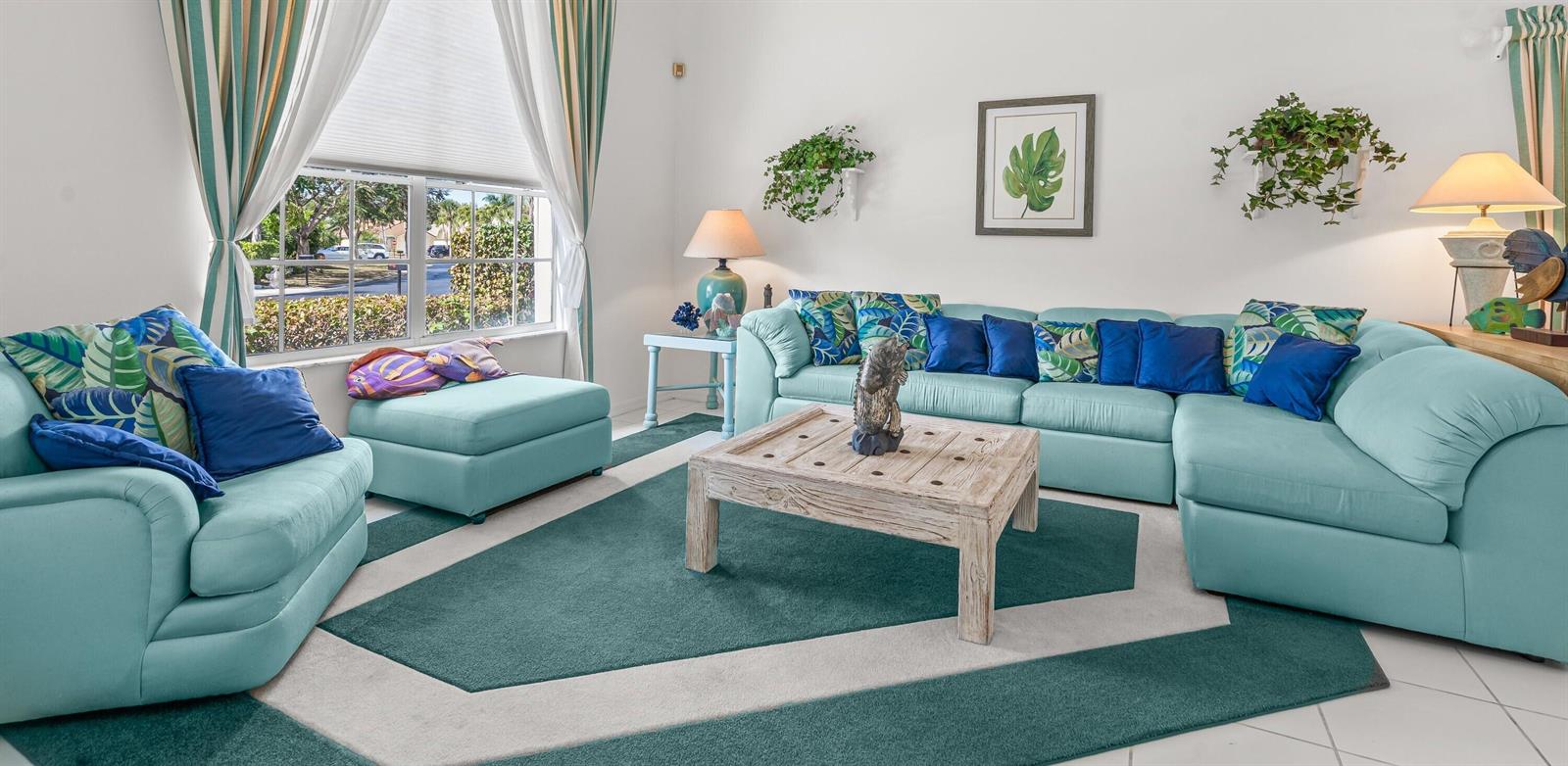 A living room features a light blue sectional sofa, matching armchair, and a wooden coffee table — 2746 Linkside Drive, Wellington FL 33414, WELLINGTON, FL