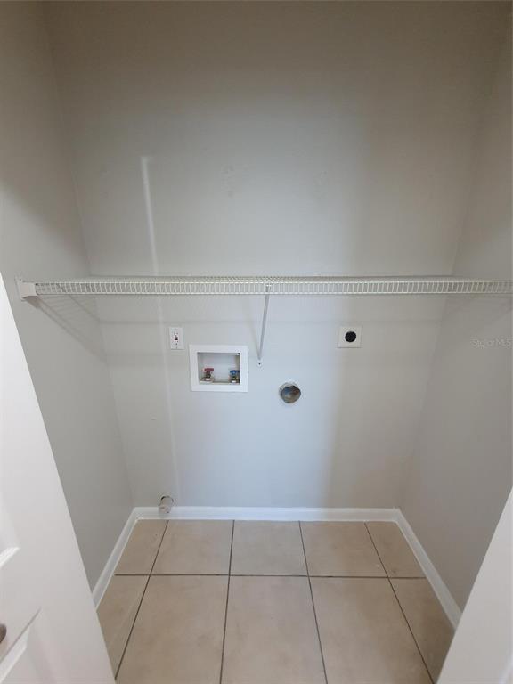 A laundry closet with tile flooring, a wire shelf, and washer and dryer hookups — 1893 ORANGE BOULEVARD WAY, PALM HARBOR, FL
