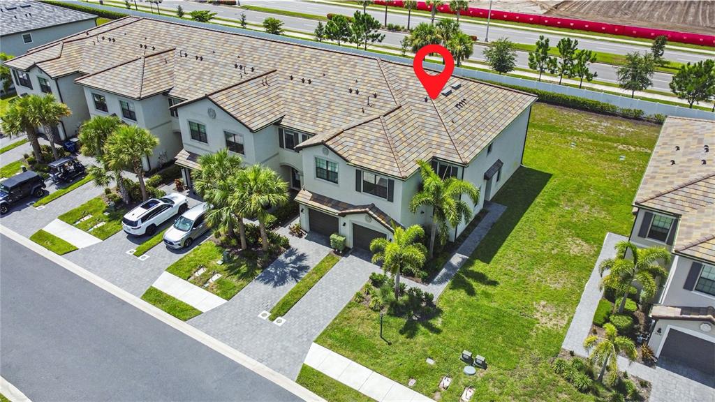 An aerial view shows a multi-unit townhouse complex with tiled roofs and paved driveways — 15148 LYLA TERRACE, BRADENTON, FL