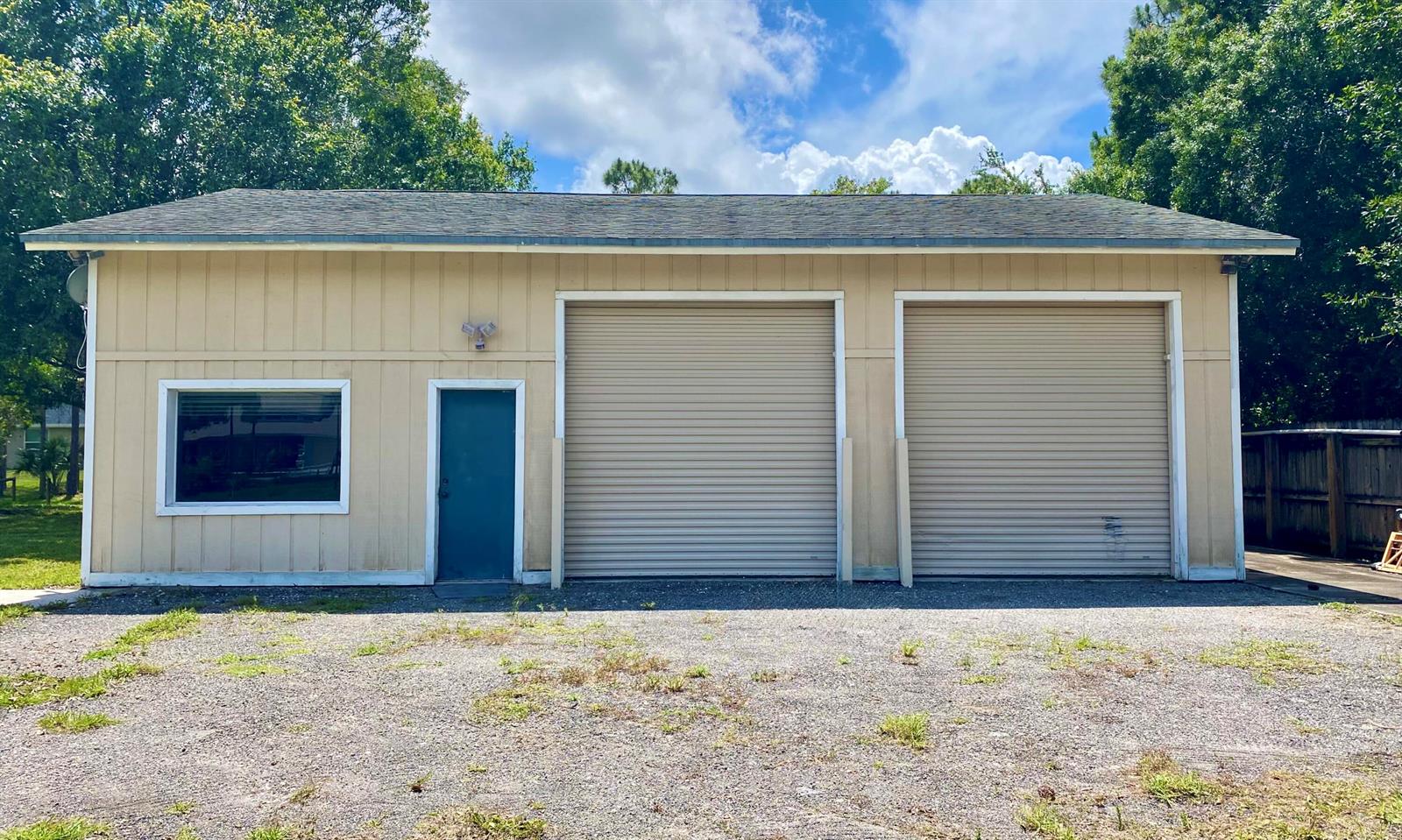 A detached garage with two roll-up doors, a single entry door, and a large window — 10531 151st Lane N, Jupiter FL 33478, JUPITER, FL