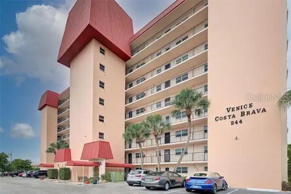 A multi-story apartment building with a red roof and a parking lot in front — 232 SAINT AUGUSTINE AVENUE UNIT 102, VENICE, FL