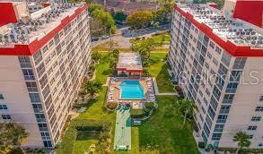 An aerial view shows two apartment buildings flanking a central swimming pool and green space — 232 SAINT AUGUSTINE AVENUE UNIT 102, VENICE, FL