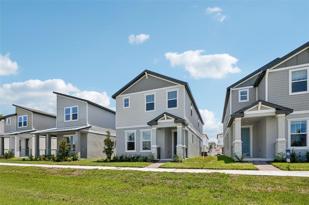 A row of three modern two-story suburban houses with gray siding and front porches — 4505 CROSS PRAIRIE PARKWAY, ST CLOUD, FL