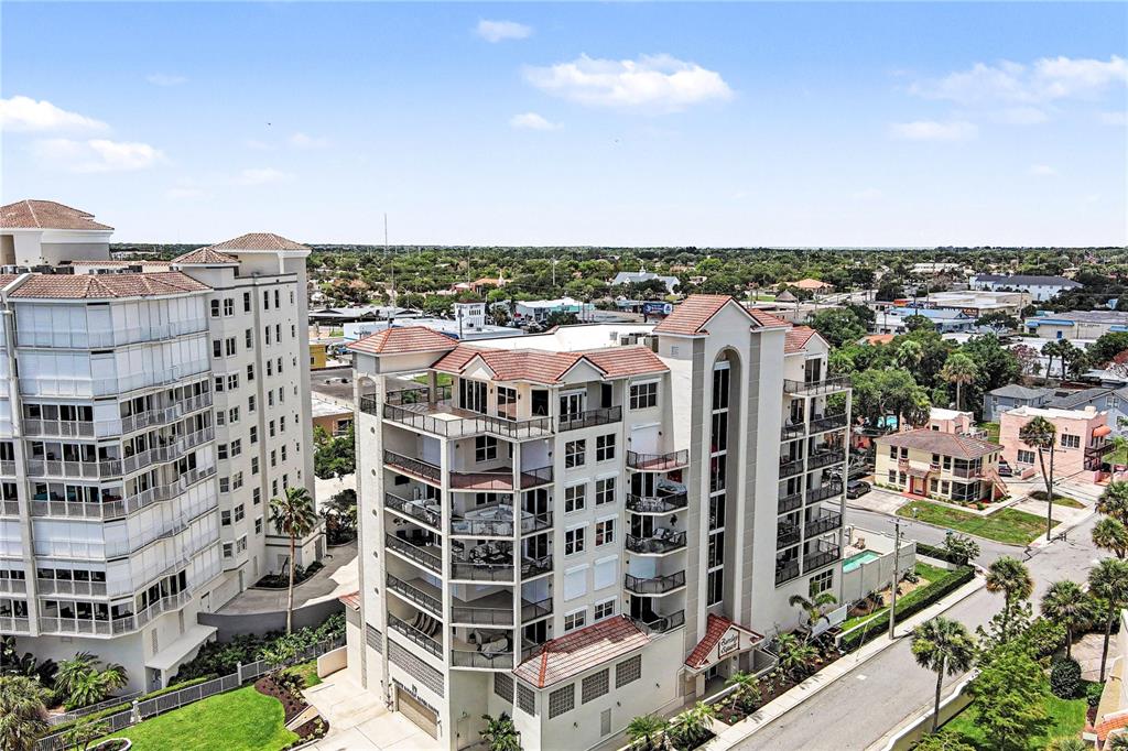 An aerial view shows two multi-story residential buildings with tiled roofs and balconies — 19 N INDIAN RIVER DRIVE UNIT PH-1, COCOA, FL