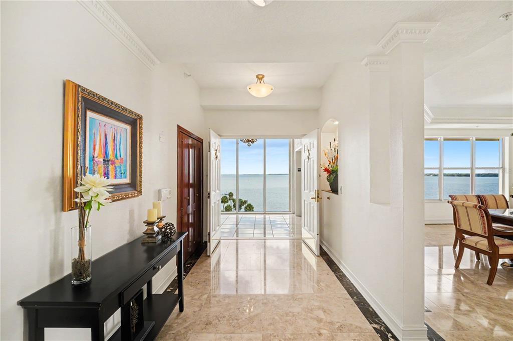 A bright foyer with marble floors leads to a glass door overlooking the ocean — 19 N INDIAN RIVER DRIVE UNIT PH-1, COCOA, FL