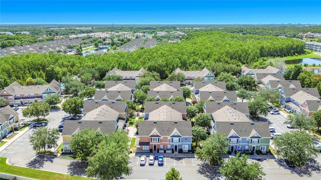 An aerial view shows several multi-story residential townhome buildings surrounded by trees and parking lots — 2208 SAN VITTORINO CIRCLE UNIT 104, KISSIMMEE, FL