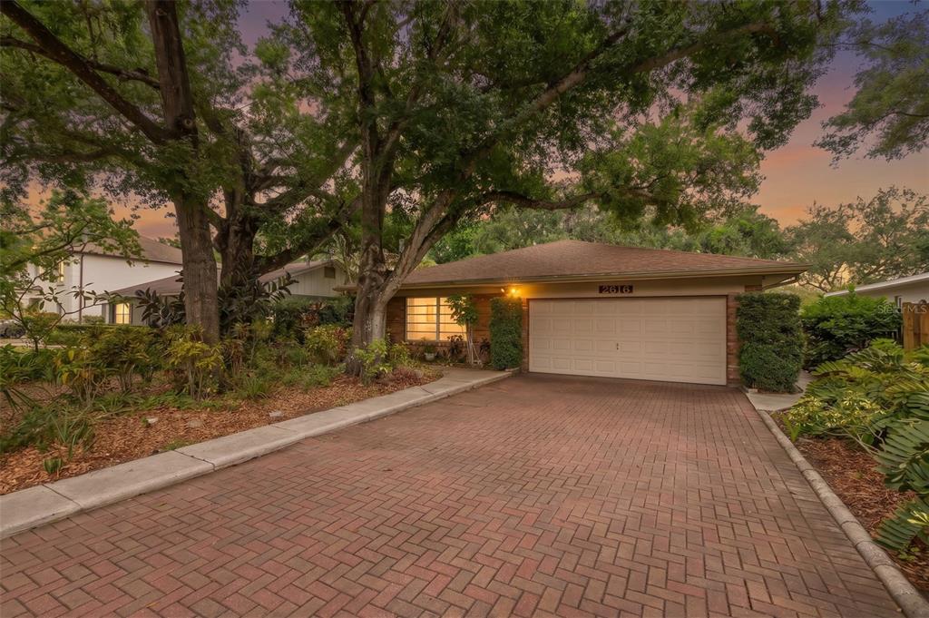 A single-story house with a brick driveway, a two-car garage, and large mature trees — 2616 S TORONTO AVENUE, TAMPA, FL