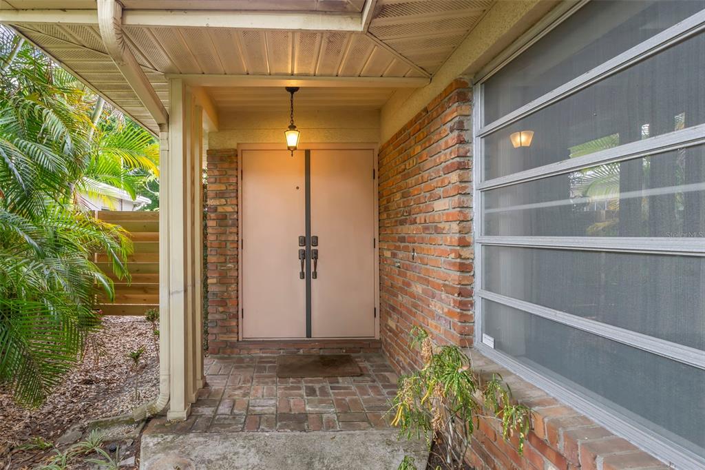 A covered entryway features double doors, brick walls, and a brick-paved floor — 2616 S TORONTO AVENUE, TAMPA, FL