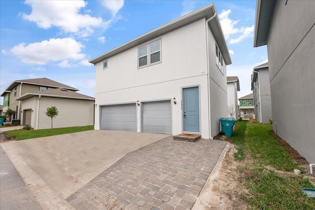 A two-story house with a white exterior, two garage doors, and a blue front door — 9741 NERUDA STREET, ORLANDO, FL
