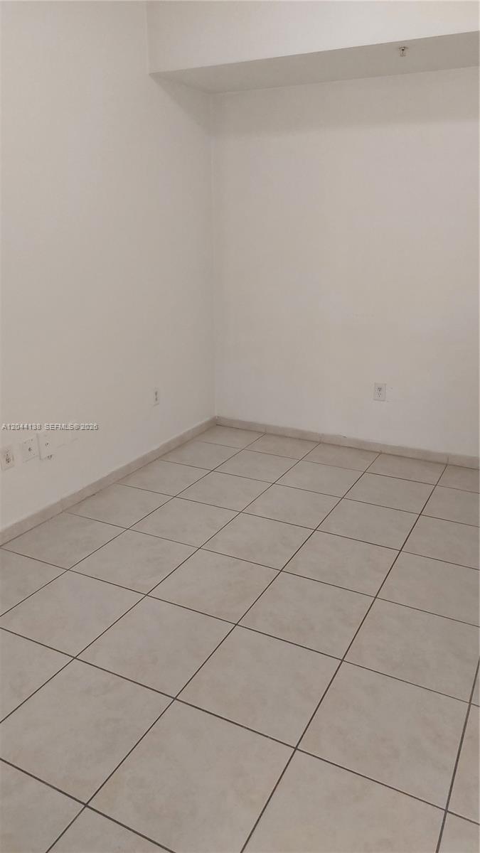 An empty room features plain white walls and light-colored square floor tiles — 7290 NW 114th Ave # 7, Doral FL 33178, DORAL, FL
