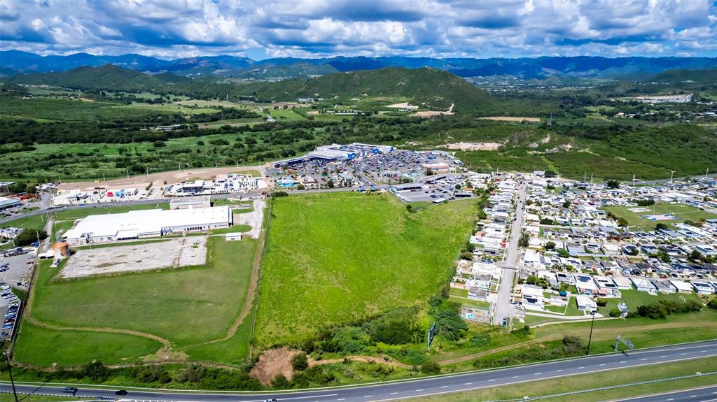 An aerial view shows a large vacant lot situated between a commercial area and residential neighborhood — PR-153 STREET, SANTA ISABEL, PR