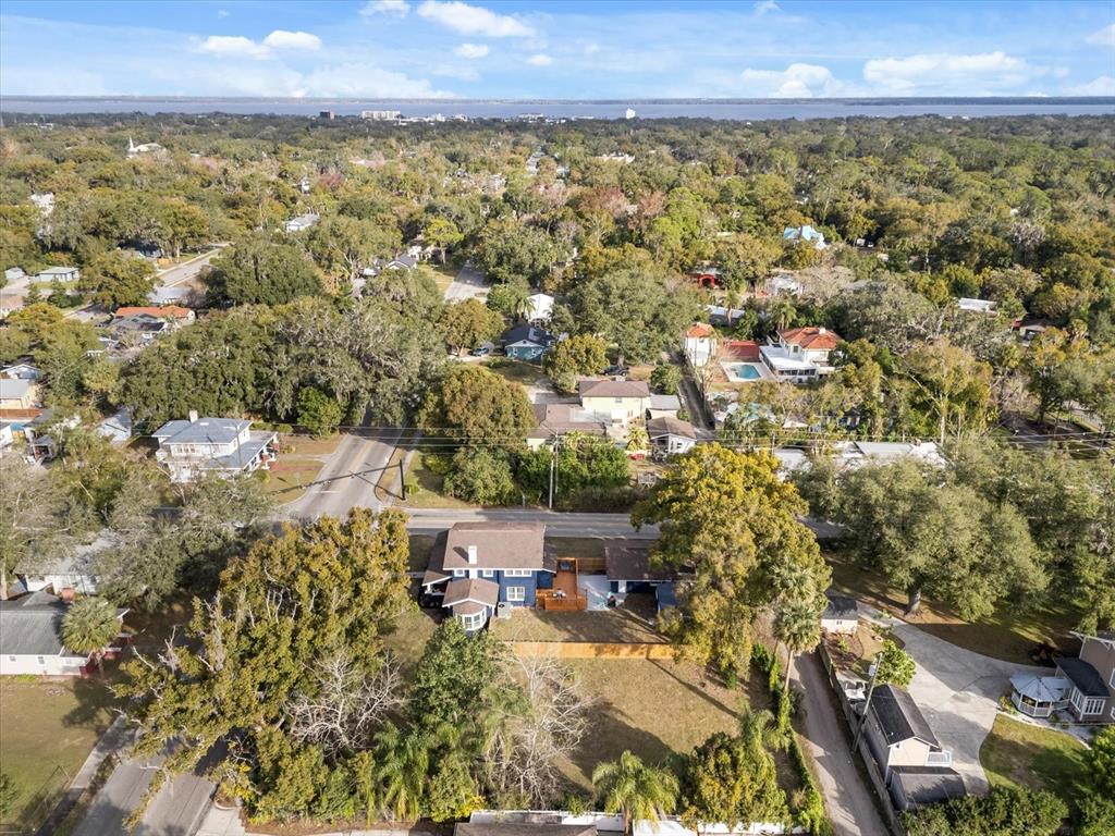 An aerial view shows a blue house with a deck surrounded by trees and neighborhood streets — TBD SANFORD AVENUE, SANFORD, FL