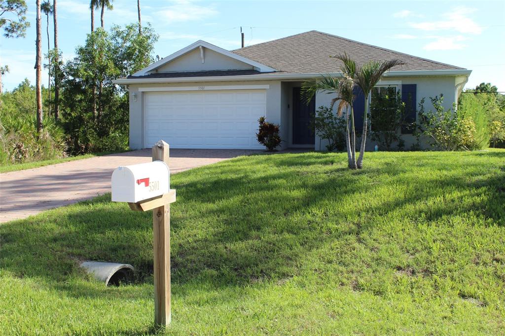A single-story house with a white garage, a paved driveway, and a mailbox in front — 5501 KEMPSON LANE, PORT CHARLOTTE, FL