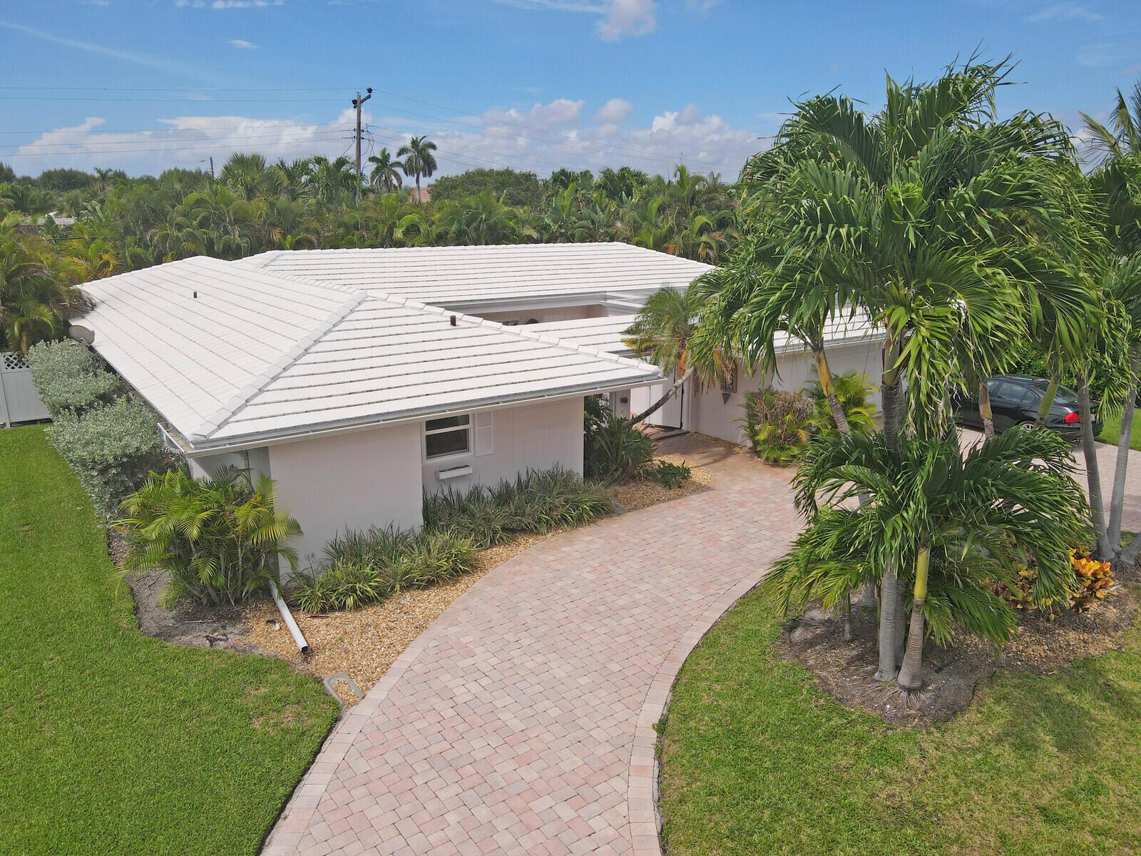 An aerial view of a single-story house with a white tile roof and brick driveway — 1211 Bimini Lane, Singer Island FL 33404, SINGER ISLAND, FL