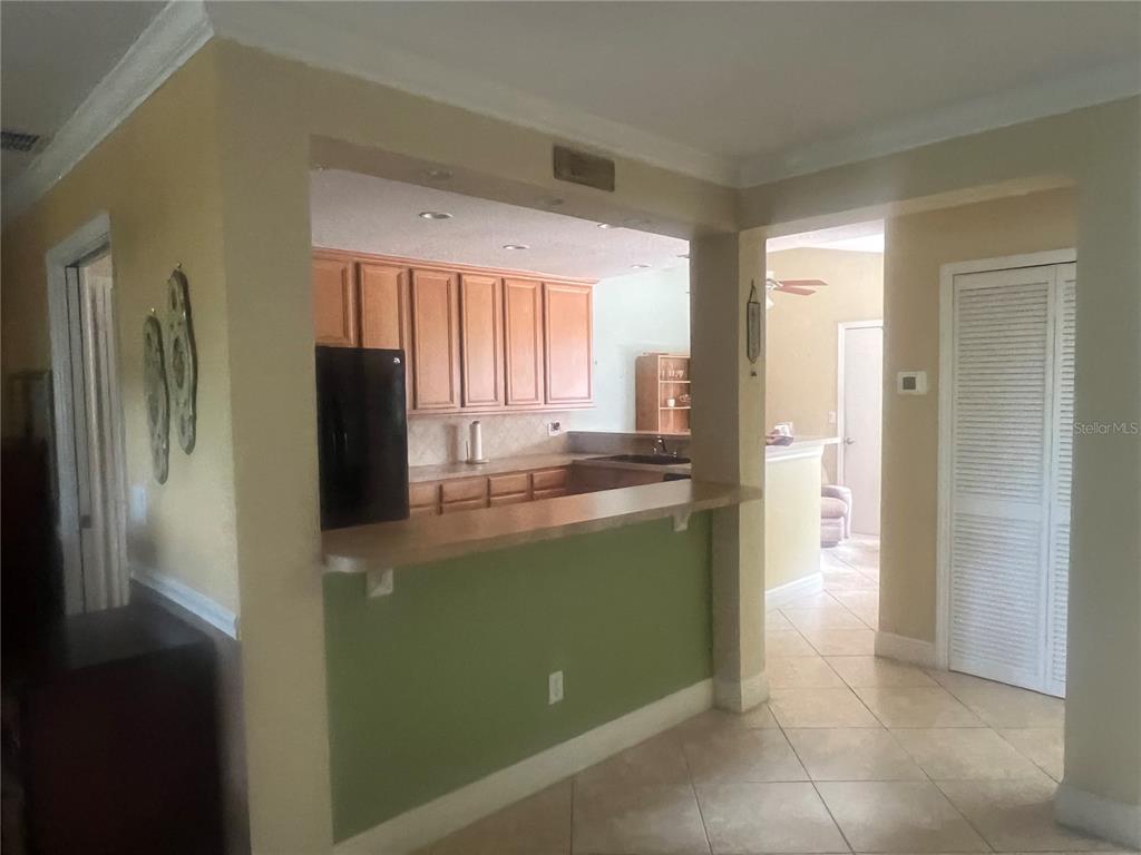 A living room features wicker chairs, tile flooring, and a large wooden display cabinet — 618 MAPLE OAK CIRCLE UNIT 112, ALTAMONTE SPRINGS, FL