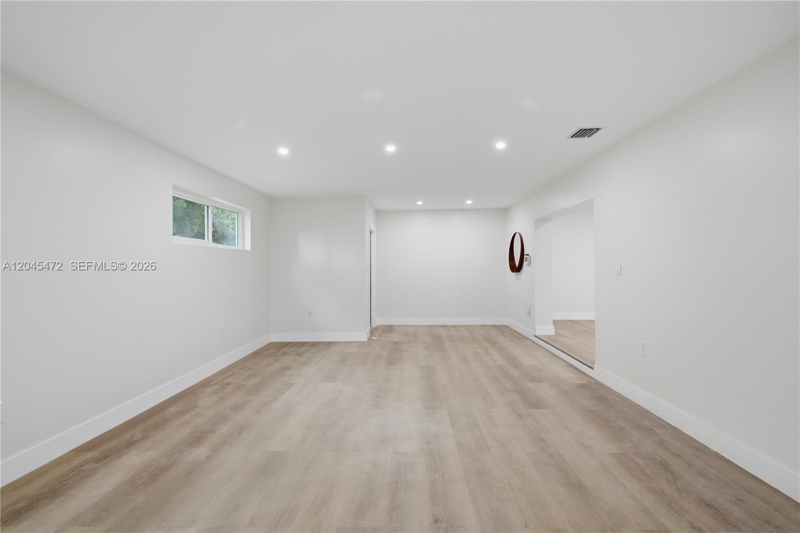 A dining room features a wooden table, grey chairs, a modern chandelier, and light flooring — 14325 NE 8th Ave, North Miami FL 33161, NORTH MIAMI, FL