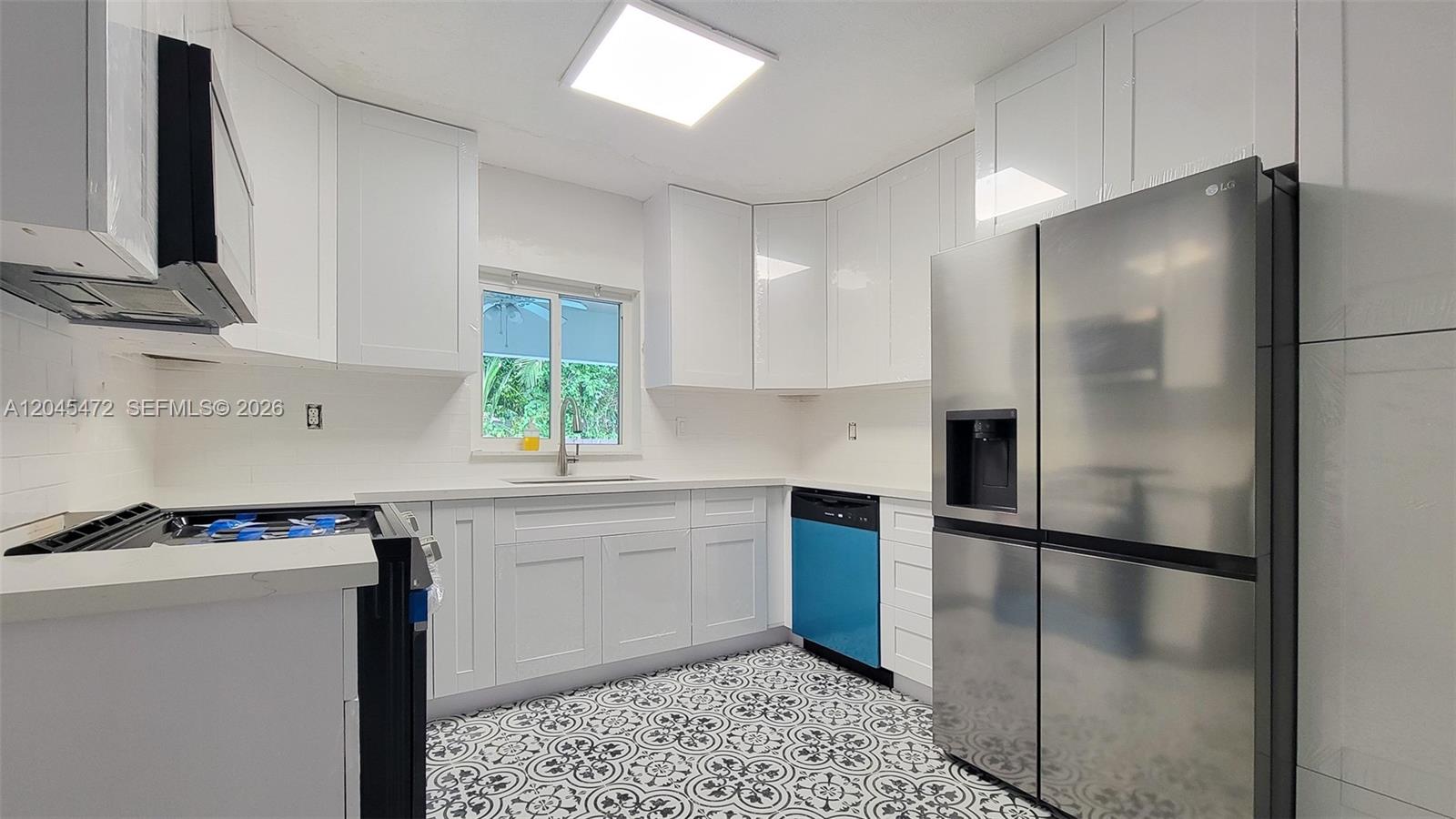A bedroom features a bed with a slatted wood headboard, a side table, and a plant — 14325 NE 8th Ave, North Miami FL 33161, NORTH MIAMI, FL