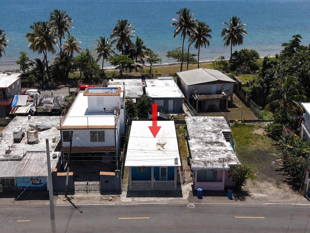 An aerial view shows a small blue house with a white roof near the ocean — 10 (70) DOCTOR. VIDAL ST. (PR-3), PUNTA SANTIAGO, PR