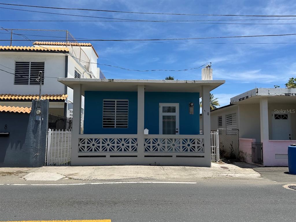 A blue single-story house features a front porch with decorative concrete block railings — 10 (70) DOCTOR. VIDAL ST. (PR-3), PUNTA SANTIAGO, PR