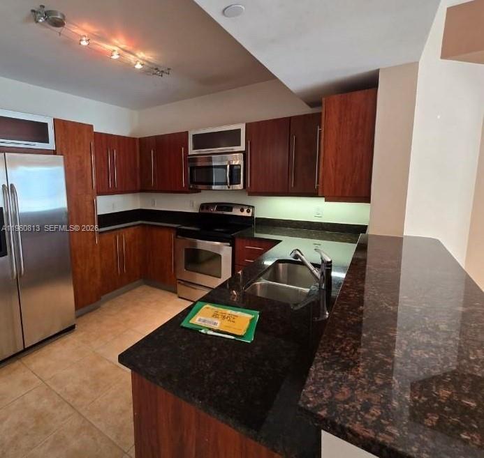 A kitchen features dark wood cabinets, stainless steel appliances, and a dark granite countertop — 7350 SW 89th St # 1804S, Miami FL 33156, MIAMI, FL