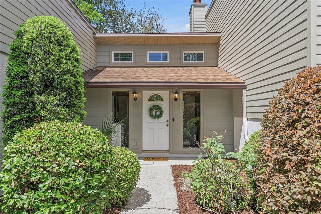 The front entrance of a house features a white door, sidelights, and three small windows — 612 NW 101ST STREET, GAINESVILLE, FL