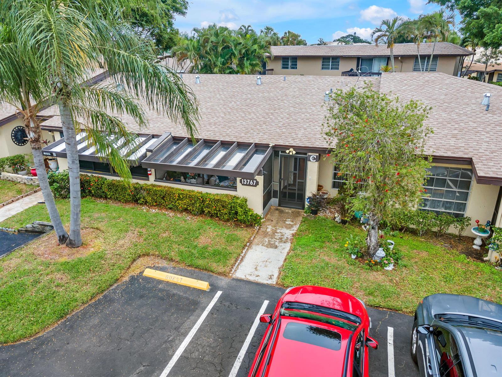 An aerial view of a single-story residential building with a glass-covered patio and parking — 13767 Via Aurora # C, Delray Beach FL 33484, DELRAY BEACH, FL