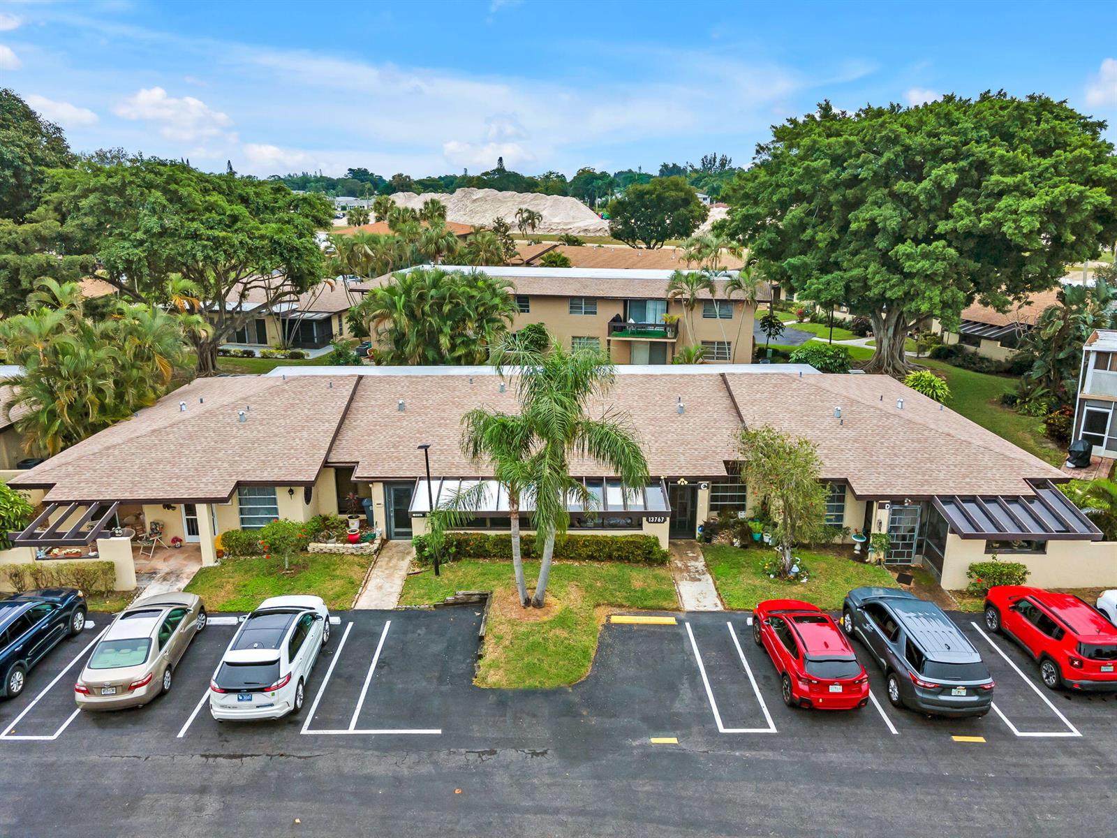 An aerial view shows a single-story residential building with a parking lot in front — 13767 Via Aurora # C, Delray Beach FL 33484, DELRAY BEACH, FL